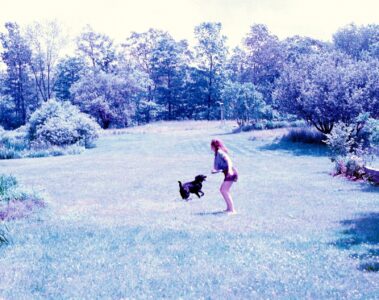 photo of girl throwing frisbee for dog