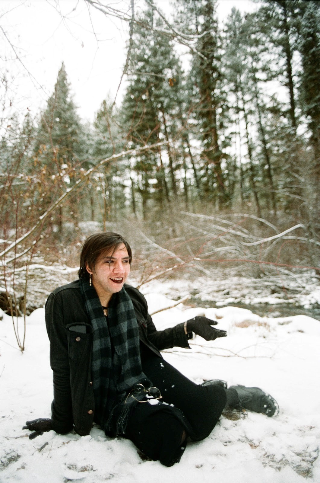 photo of musician ash nataanii sitting in a snowy forest