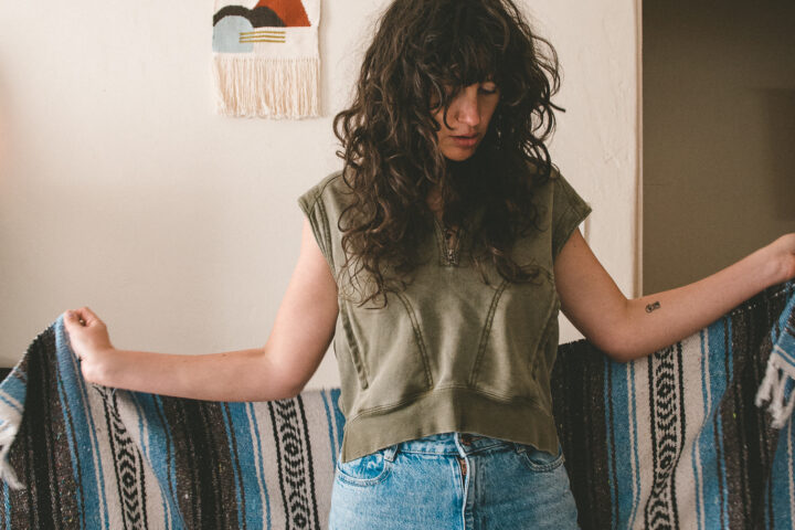 a picture of the artist Magana holing a knitted shawl