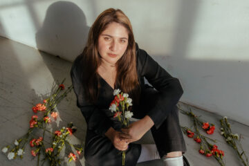 A picture of the artist Zoya Zafar holding flowers
