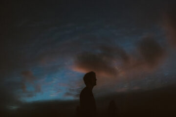 photograph of David Allred in silhouette against an evening sky