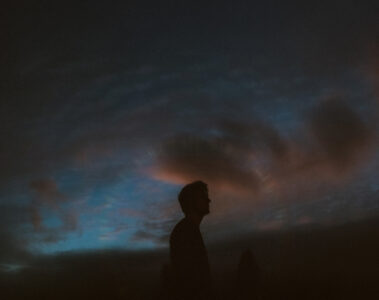 photograph of David Allred in silhouette against an evening sky